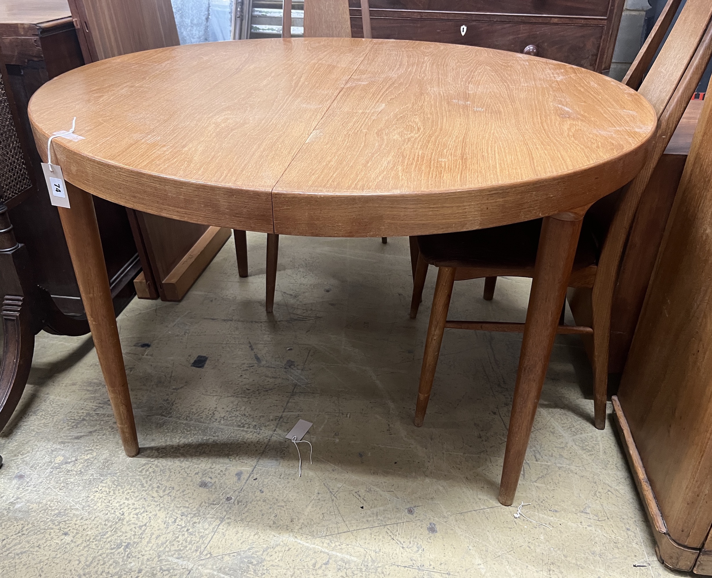 A mid century circular teak extending dining table, length 130cm extended, two spare leaves, depth 120cm, height 72cm